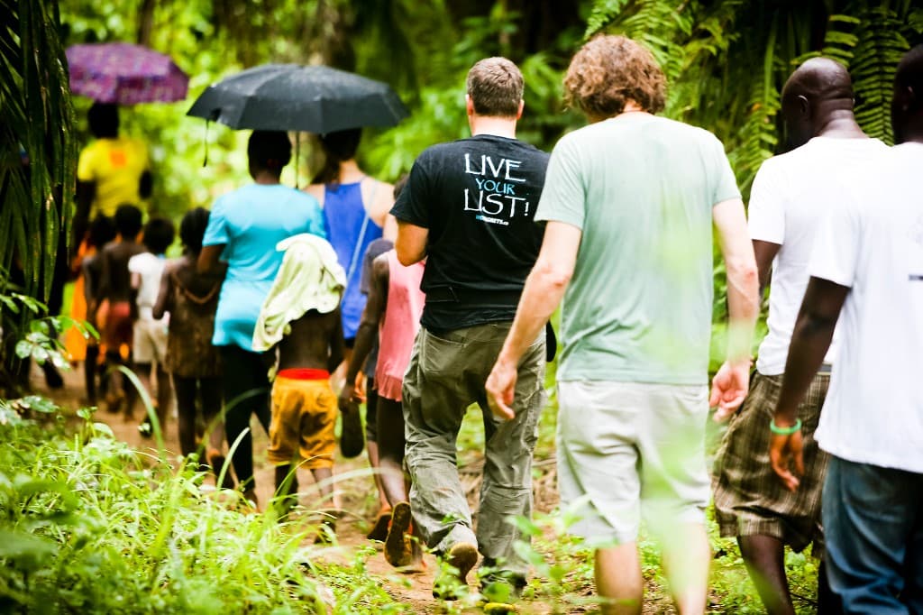 group trekking through lush jungle path, rainforest adventure, Africa expedition