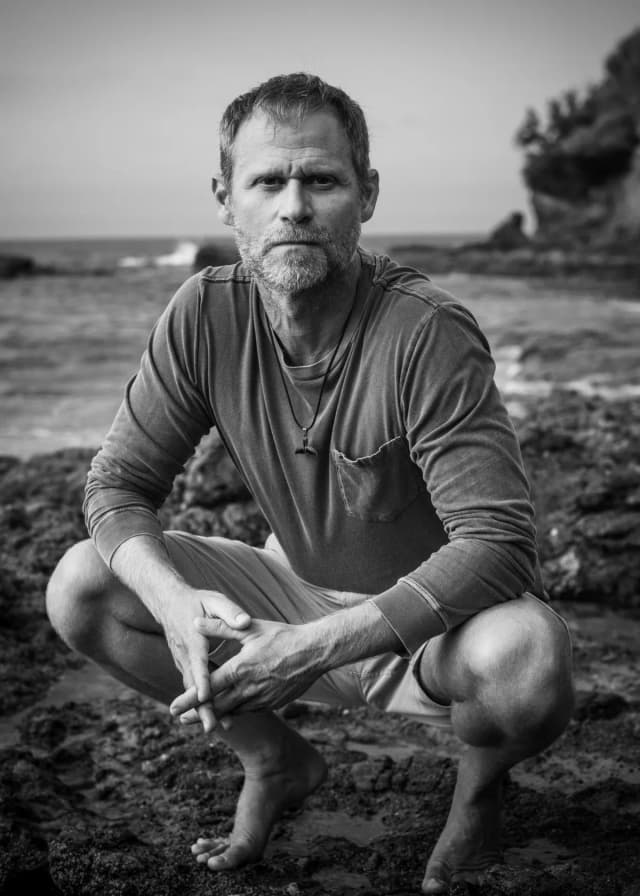 professional portrait of male entrepreneur Rich German in his 50s, outdoor adventure setting, warm natural lighting, confident expression, casual adventure attire, ocean or mountain background